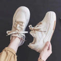 Women's pink low top sneaker with a rubber platform sole on a white background.