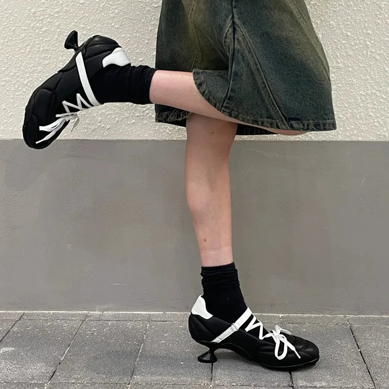 Women's silver low-top sports shoes with front lace-up, bow detail, and a mid heel on a white background.