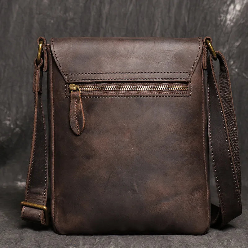 Men's genuine leather messenger bag in retro solid colour black shown on a table