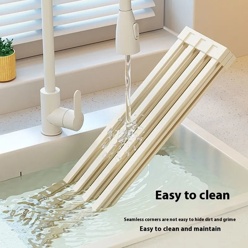 Milky white foldable stainless steel draining rack showing tri-fold design with dishes