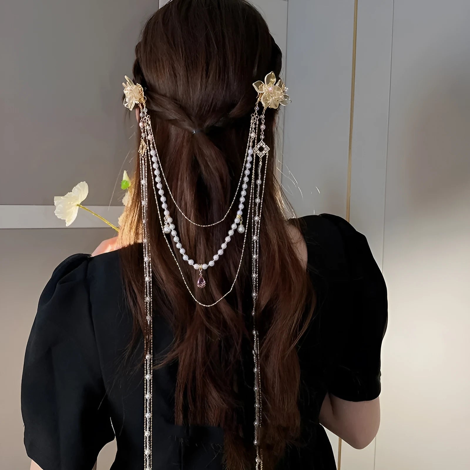 Gold acrylic hairpin with a pearl and diamond flower decoration and a long tassel.