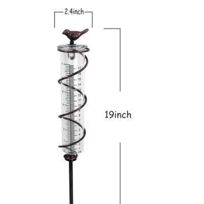 Hummingbird-shaped glass rain gauge on a cast iron base for garden precipitation measurement.