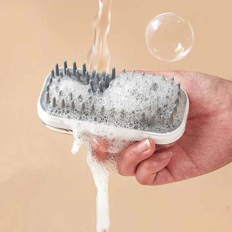 Grey silicone bath brush for pets with soft bristles and ergonomic handle on white background