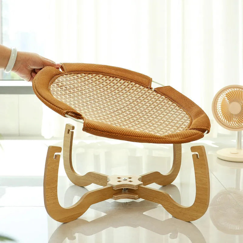 Brown woven rattan pet hammock bed for cats and dogs on a cool mat.