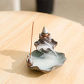 Square ceramic reverse flow incense burner with purple clay finish and lotus plum blossom decoration.