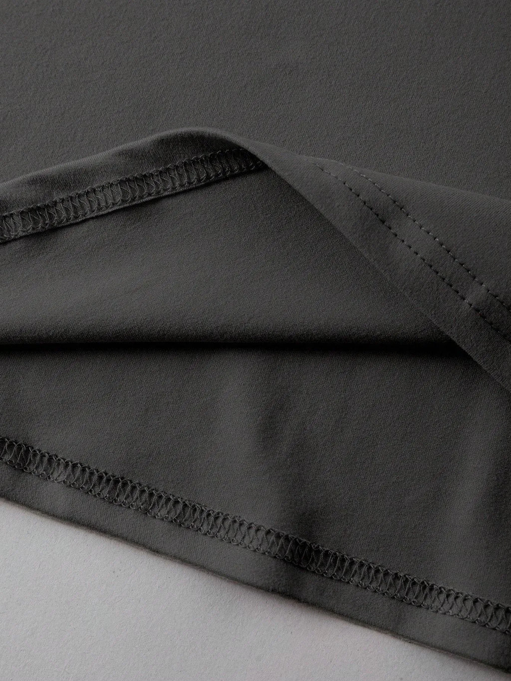 Loose fit short sleeve cotton t-shirt in black on a hanger, showing round neck collar.