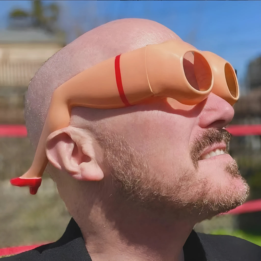 Orange plastic novelty sunglasses featuring a leg and hip design theme.