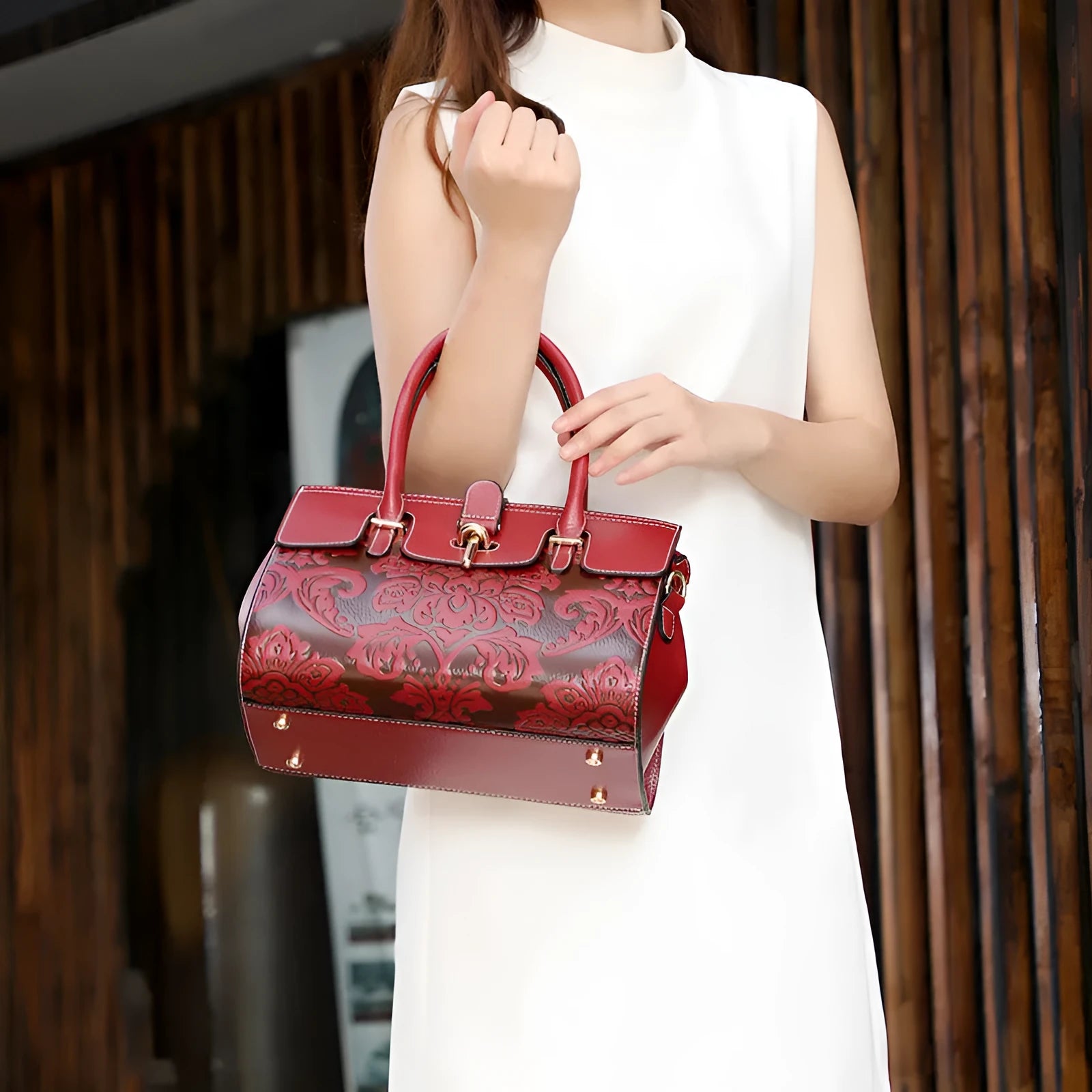 Red genuine leather women's crossbody bag with oval shape and embossed detailing.