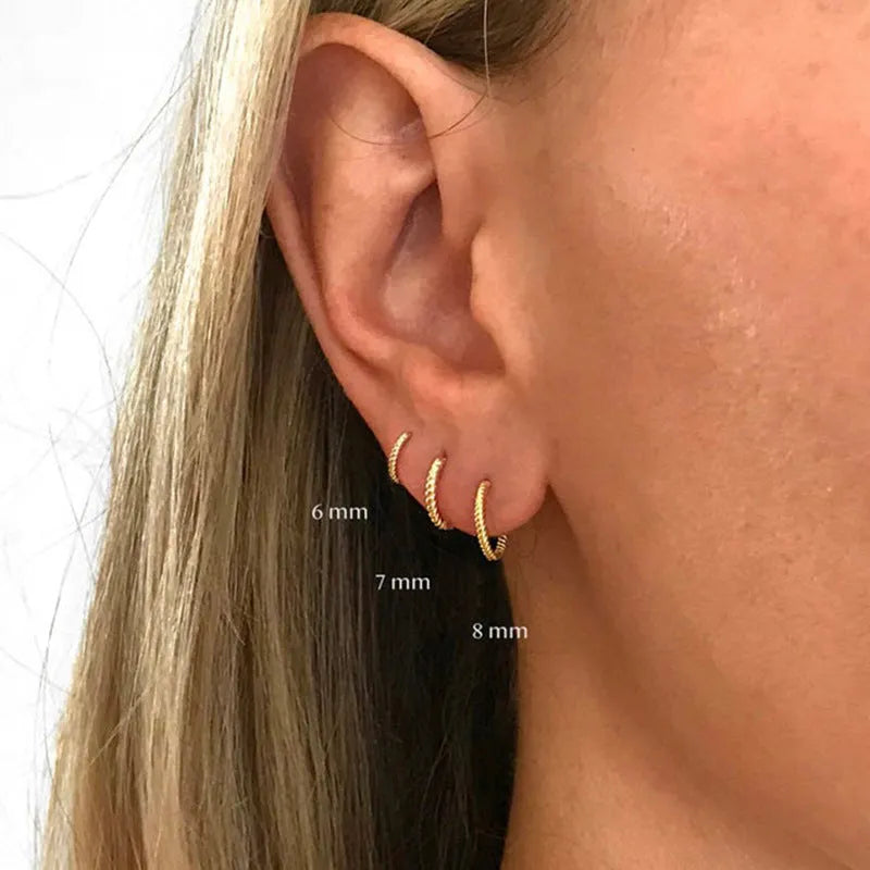 A pair of twisted string round geometric earrings made from Sterling Silver, shown in a gold electroplated finish.