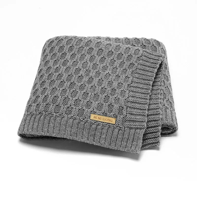 Solid colour acrylic baby blanket with textured lines, shown in a neutral shade, dimensions 70x90 cm