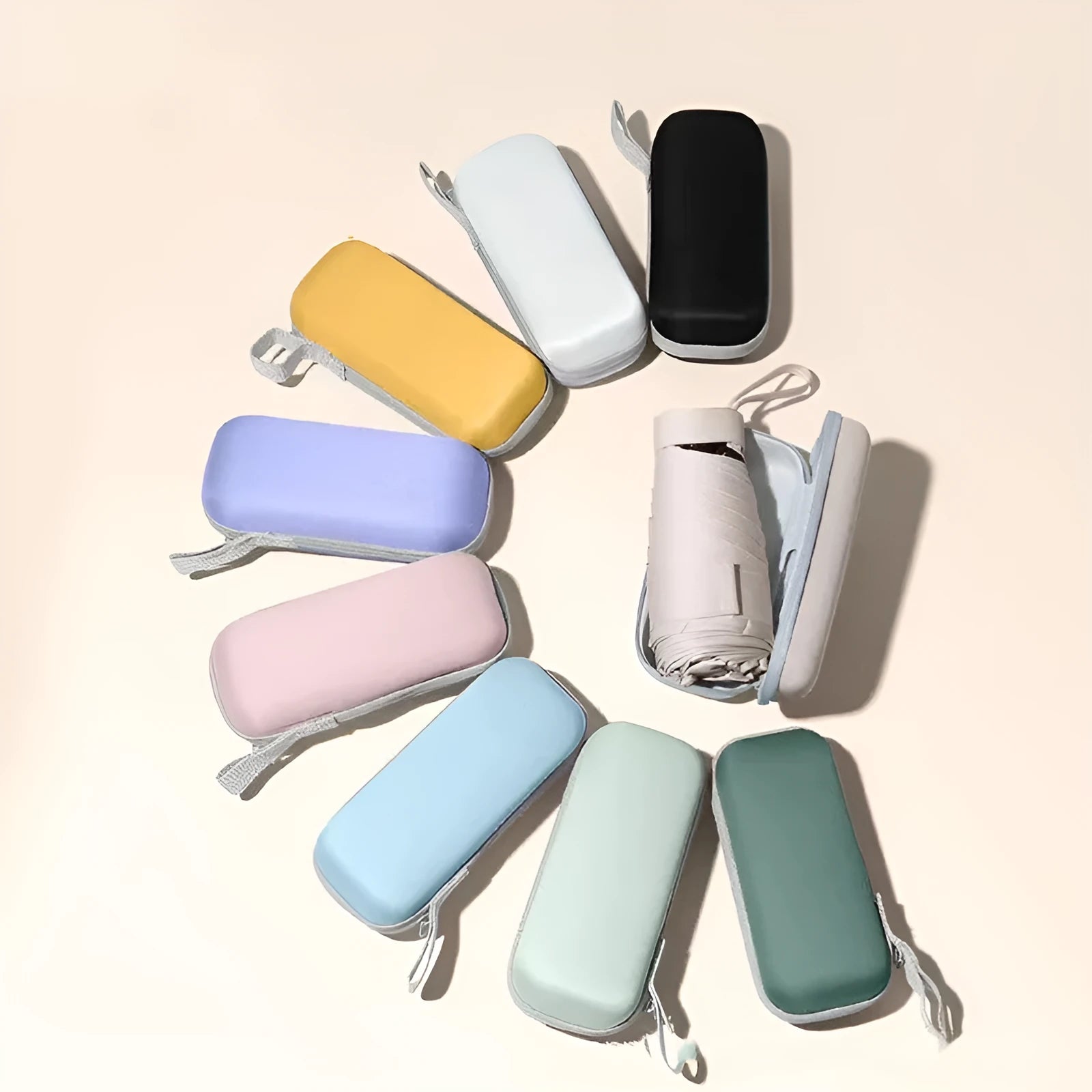 Compact six-fold umbrella in mint green with a capsule box, showing its folded size and rubber handle.