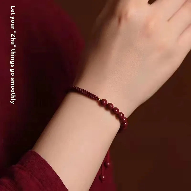 Braided rope bracelet with cinnabar beads in 8mm diameter and wine red colour