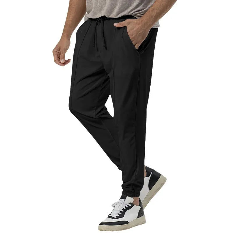 Men's gray loose fit tapered casual sweatpants with elastic waistband on a neutral background.