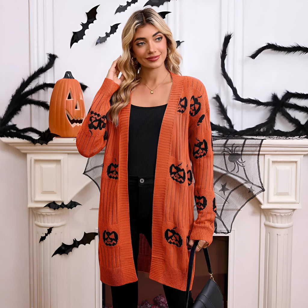 Women's black Halloween cardigan with jacquard-knitted orange pumpkin head pattern, shown as a straight-cut medium-length coat.
