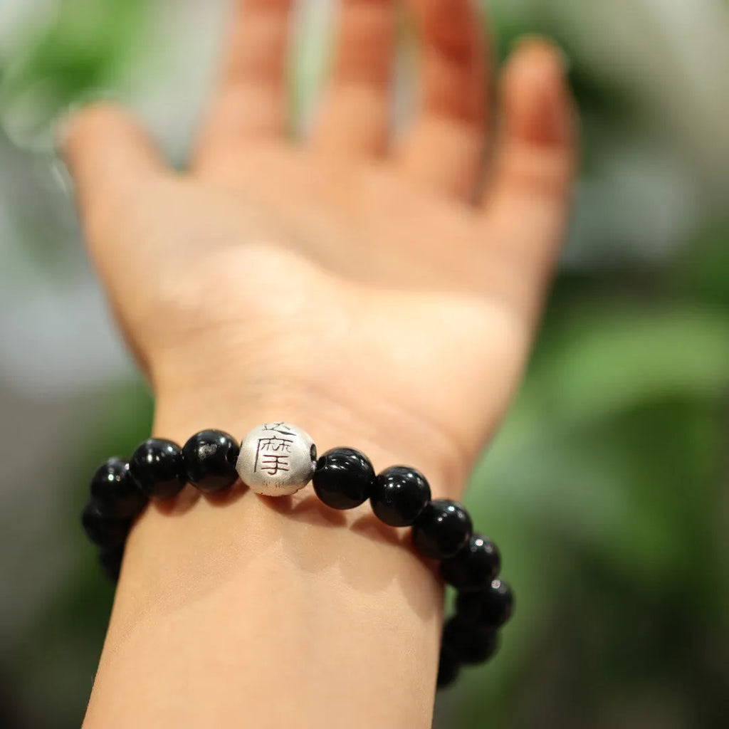 Women's black agate bracelet with sterling silver clasp showing 10mm stones and Chinese style design.