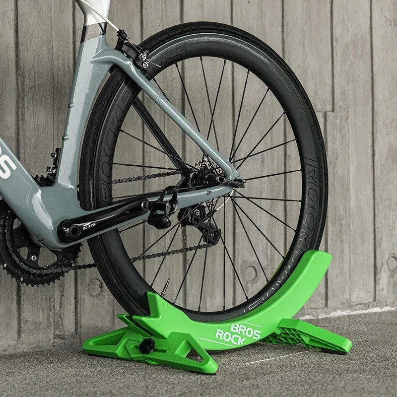 ABS wall-mounted bike parking rack holder in black holding a bicycle frame against a garage wall