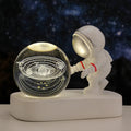 Clear resin crystal ball night light with glowing astronaut pattern on USB base