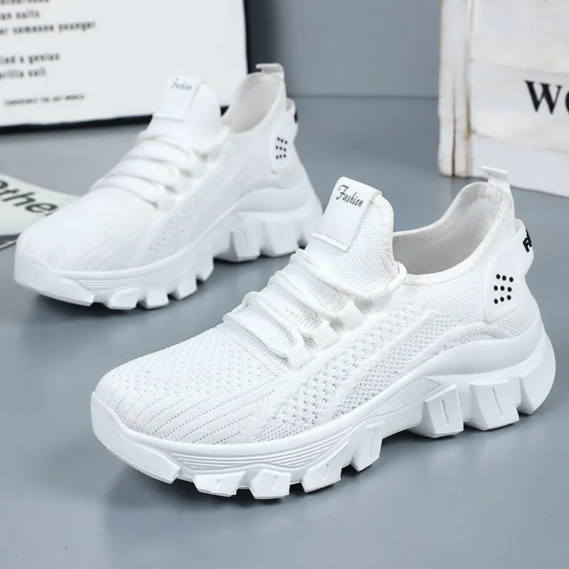 Women's white Flyknit running shoes with a thick PVC sole and lace-up front.