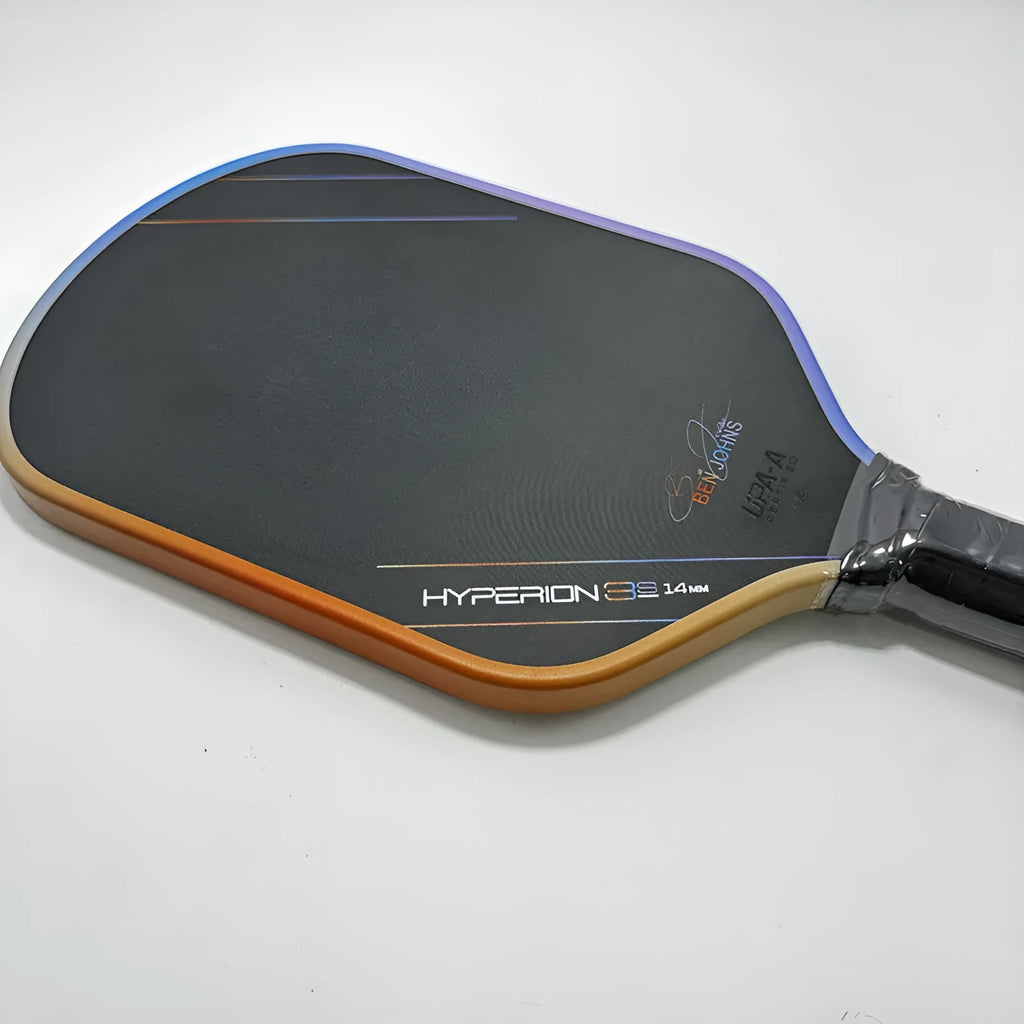 Matte black pickleball racket with Teflon cloth pattern, showing carbon fibre construction and honeycomb core.