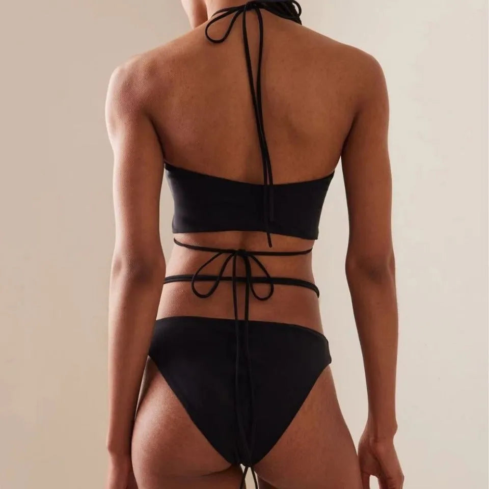 Women's split lace-up bikini swimsuit in black, two-piece set with bra and shorts on plain background