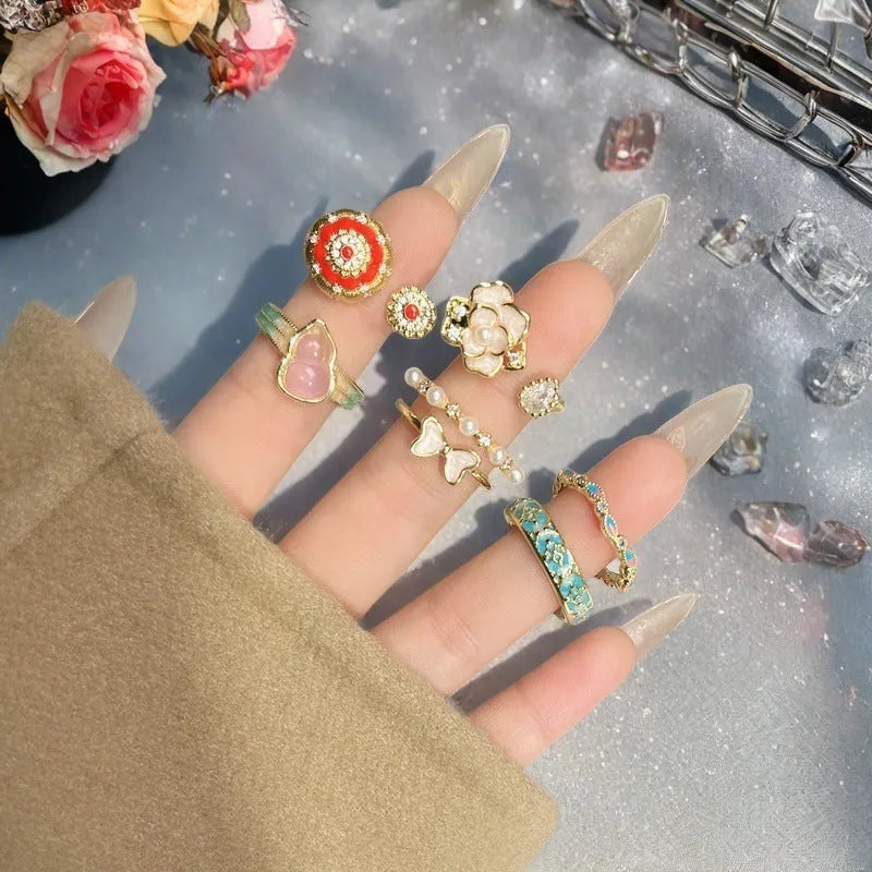 Adjustable copper ring with vintage oil dripping gourd, flower, and bow design and inlaid zircon stones.