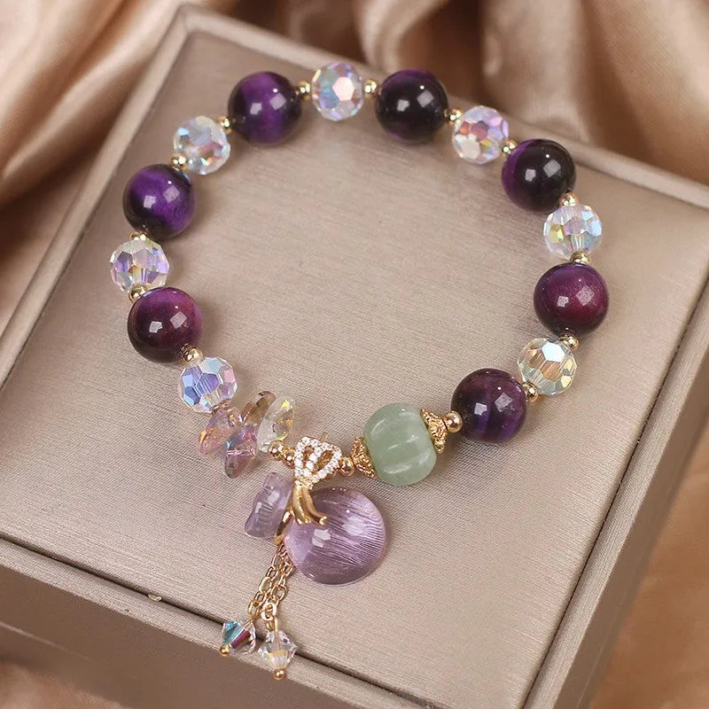 Women's crystal bracelet with purple Tigereye money bag pendant and clear rhinestone accents