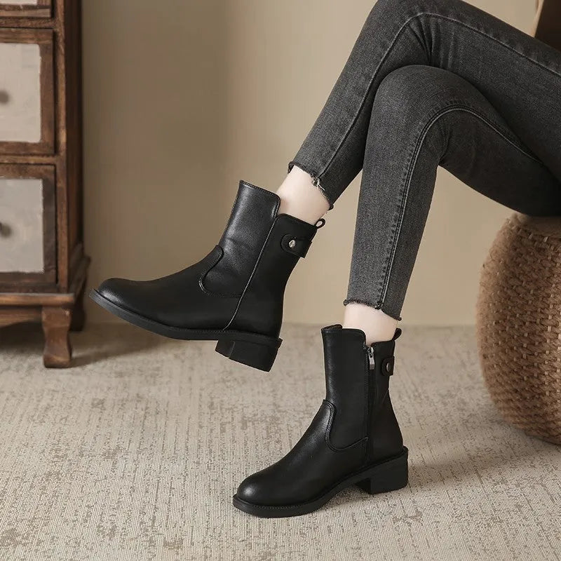 Black women's ankle boots with side zip, round toe, and low rubber sole