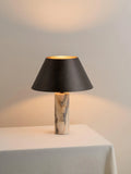 Black marble table lamp with modern minimalist design on wooden surface