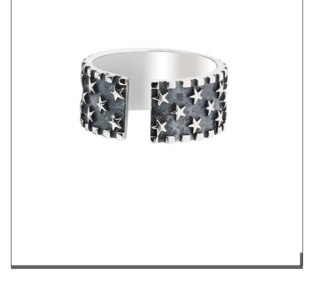 Adjustable open-band sterling silver ring with a raised five-pointed star geometric design.