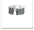 Adjustable open-band sterling silver ring with a raised five-pointed star geometric design.