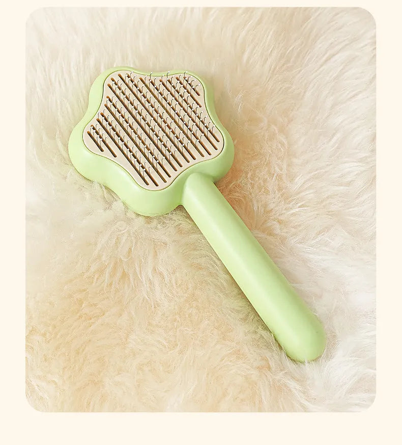 Green self-cleaning stainless steel pet comb for grooming cats and dogs on a white background