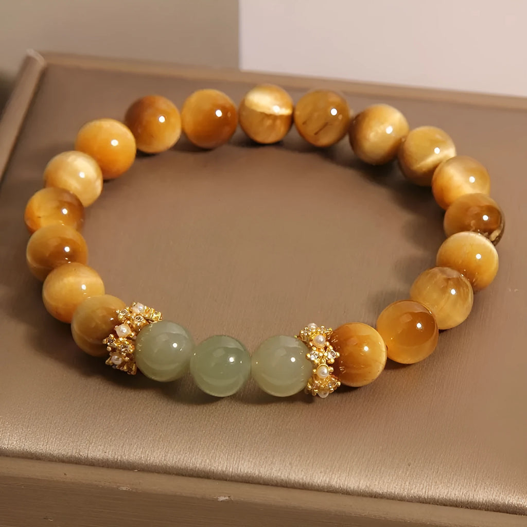 Natural yellow tiger's eye bracelet with U-shaped design showing auspicious patterns and traditional symbolic charms