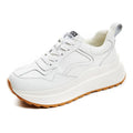 Beige women's low-top leather casual shoes with cross strap and English muffin heel on a white background.