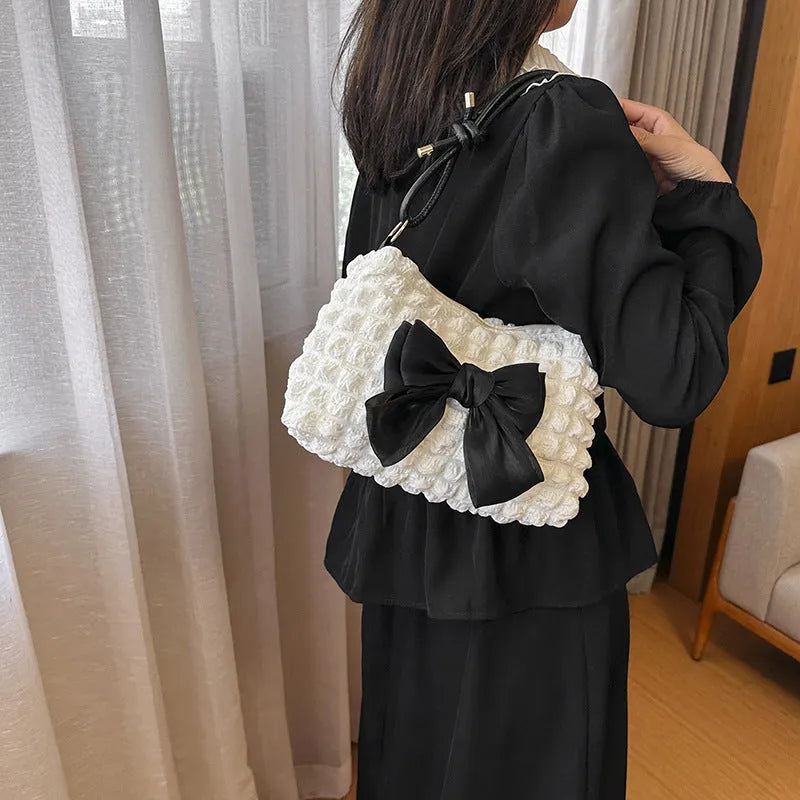 Black canvas horizontal square women's handbag with a single shoulder strap and an outer sandwich pocket.