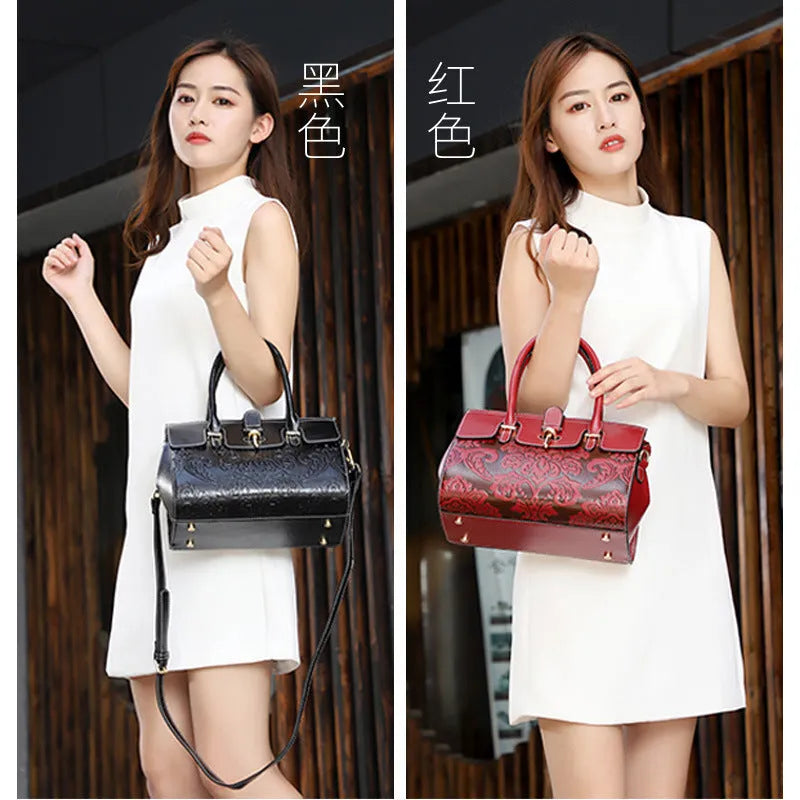 Red genuine leather women's crossbody bag with oval shape and embossed detailing.