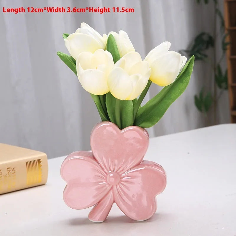 White porcelain clover ceramic vase in European style on a desktop.