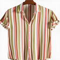Man wearing a short sleeved shirt with a colourful digital printed pattern on the front.