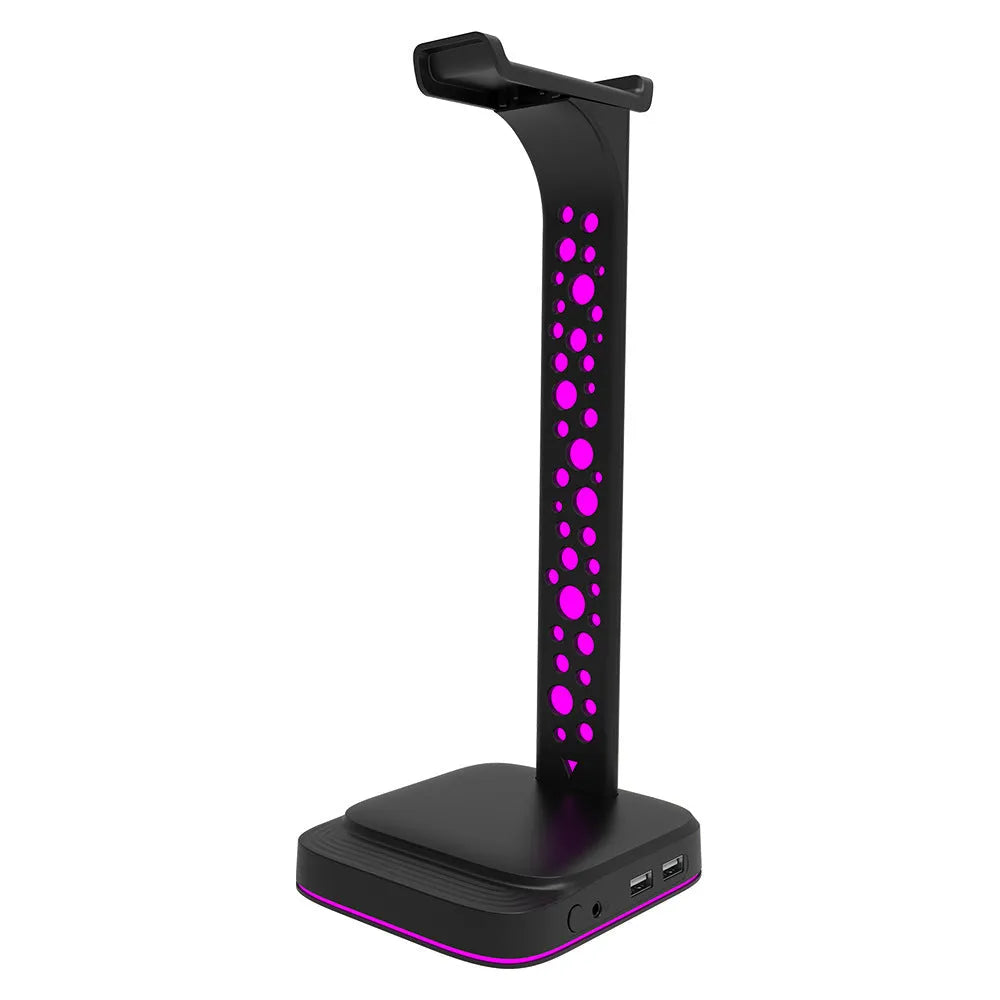 RGB colour changing headphone stand with dual USB ports on a desk next to a gaming headset.