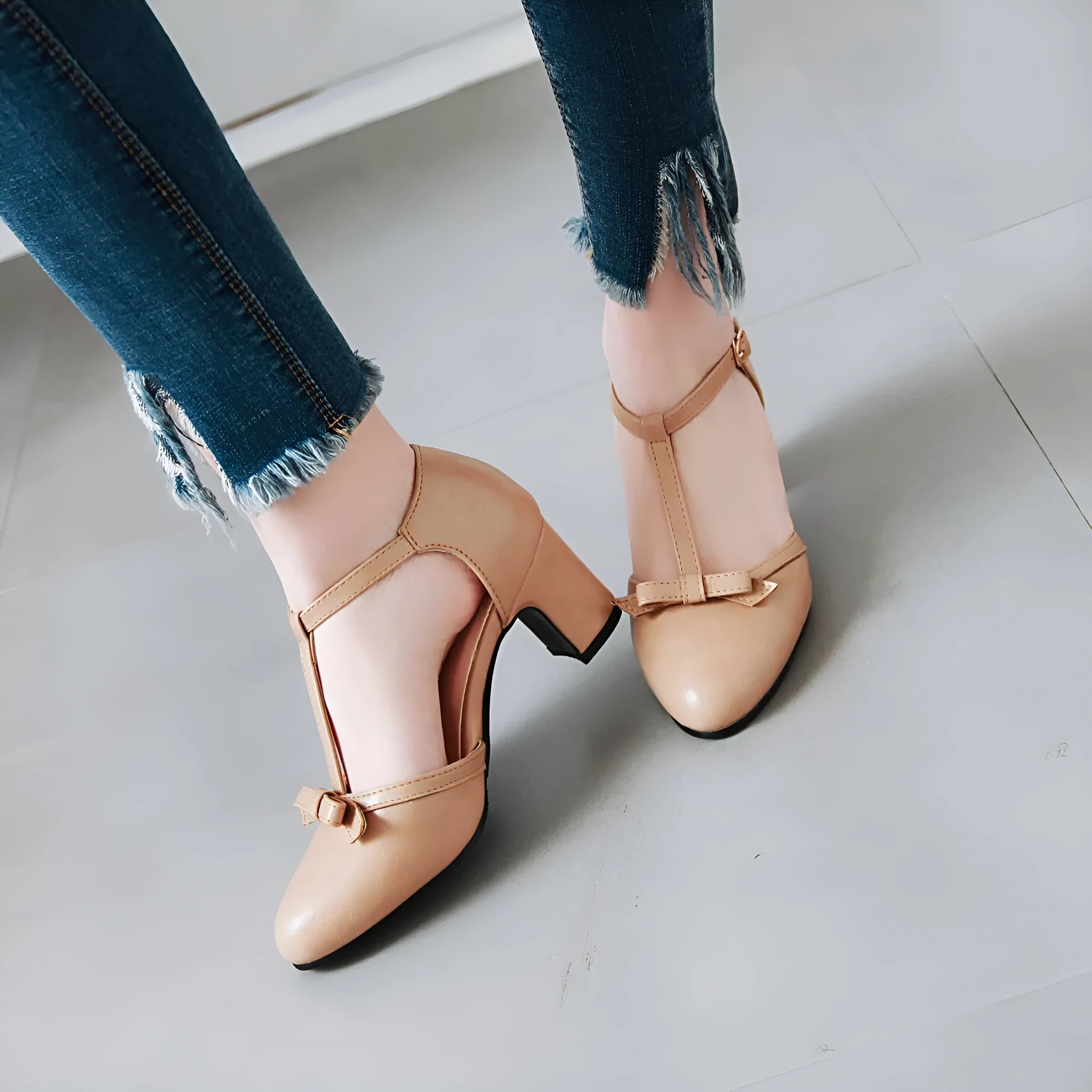 Women's apricot coloured chunky heel sandals with a buckle strap and bow tie detail on a 6.5cm heel.