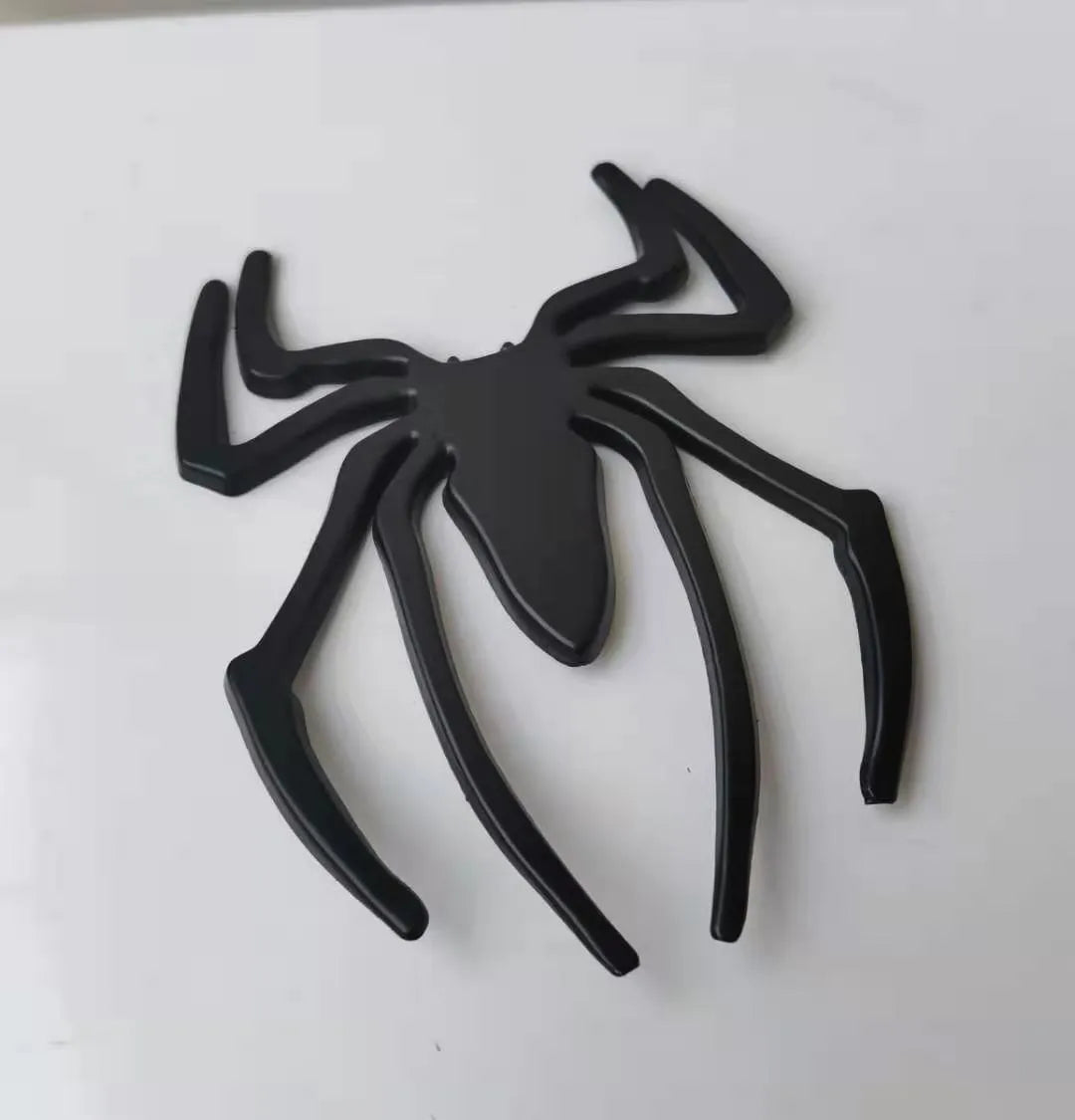 3D metal spider car bumper sticker in gold, silver, black, or red on a white background