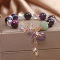 Women's crystal bracelet with purple Tigereye money bag pendant and clear rhinestone accents