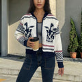 White women's wool zip cardigan with lapel collar and black jacquard contrast stripes.