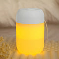 White cylindrical USB mini humidifier with charging cable on desk