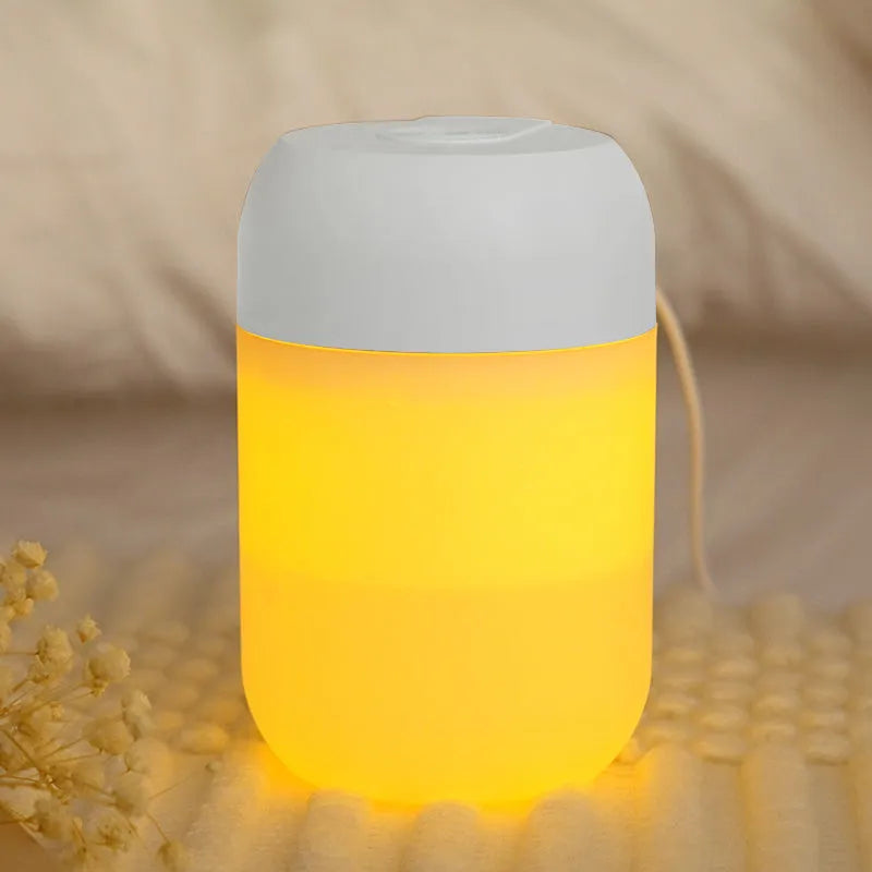 White cylindrical USB mini humidifier with charging cable on desk