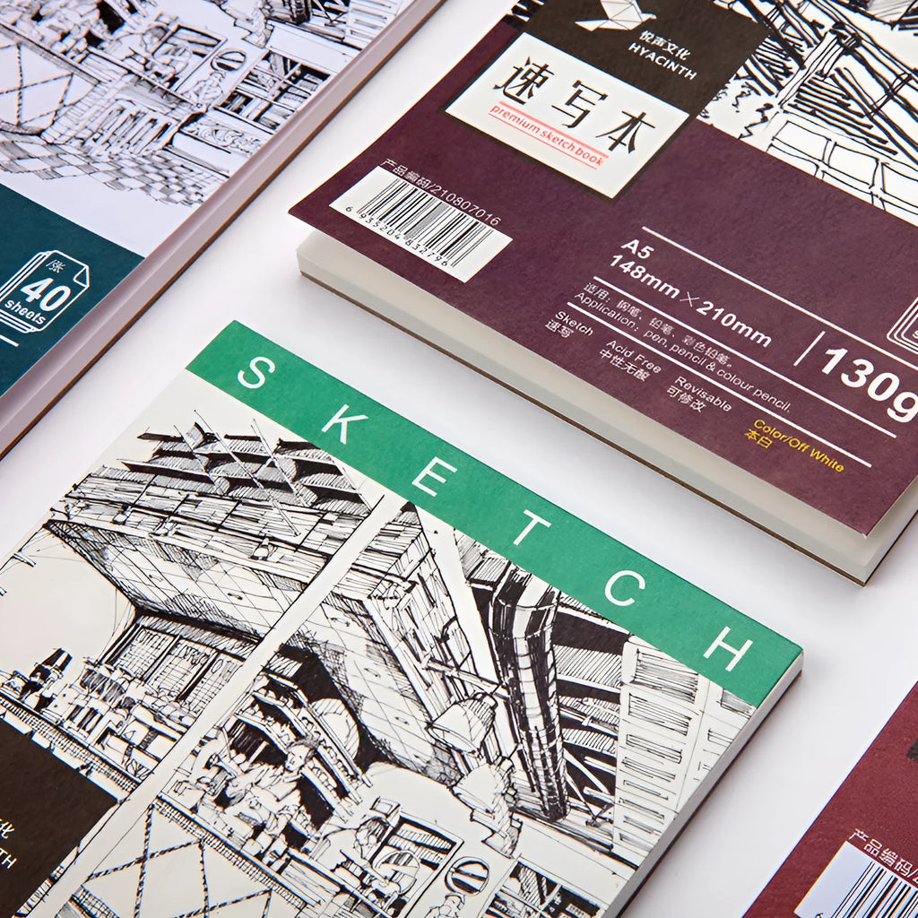 A4 coil-bound sketchbook with blank pages and 160g paper, open on a table