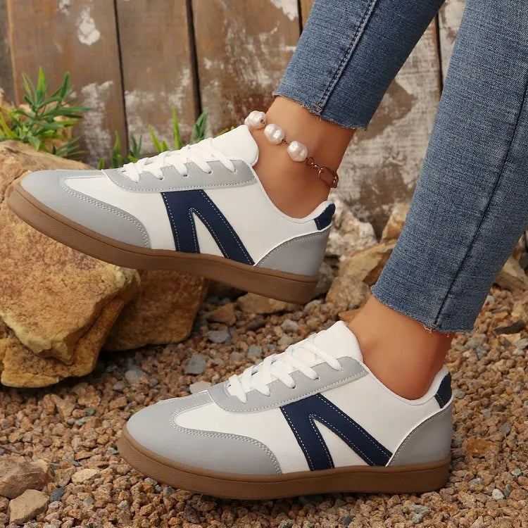 Women's blue flat German training shoes with artificial PU upper and rubber sole, low-top profile, side view