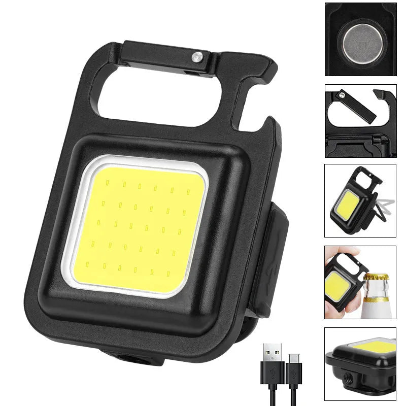 Black aluminium alloy COB keychain flashlight on a metal surface, magnetic base attached, 6x4.2cm size, with foldable handle extended