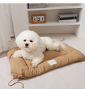 Beige cage cushion tied in a wire dog crate with soft padding for small pets