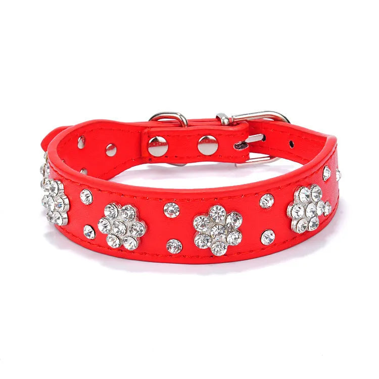 Close-up of a black PU leather dog collar with a studded rhinestone flower pattern and a metal D-ring.
