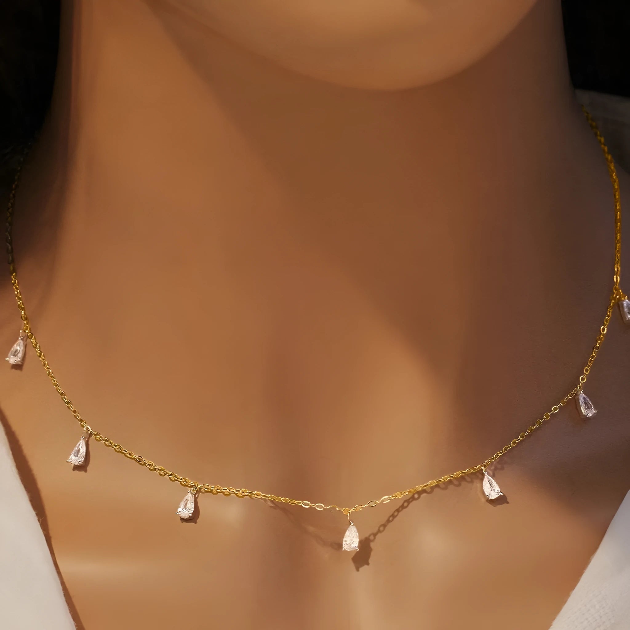 Silver drop-shaped artificial zircon necklace on an O-chain with triangular detail, showing rose gold and golden yellow colour options.